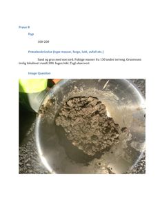 Fotografi av en jordprøve i en metallbøtte med tilhørende tekstbeskrivelse av prøven.