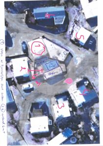 Situasjonsplan med håndtegnede markeringer av bygninger, vognplasser og en sirkel som indikerer et fokusområde.