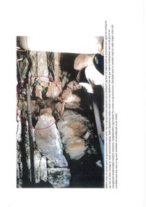 Fotografi av en grunnmur med steiner og en kollapset del, med en rød sirkel som markerer et område.