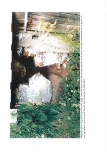 Fotografi av en grunnmur med en provisorisk rast og dørkarm.