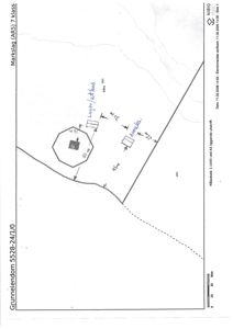 Situasjonsplan som viser tomtens grenser, en bygning (hus) og en garasje med angitte mål og avstander.