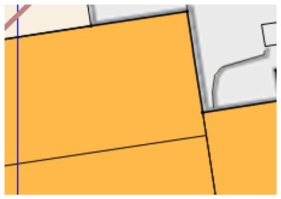 Dette bildet viser en detalj fra en situasjonsplan eller tomteplan. De store fargede områdene (gult/oransje) representerer sannsynligvis eiendomsarealer, mens de hvite områdene kan være bygninger eller andre arealbrukskategorier. Linjene markerer grenser mellom tomtene.