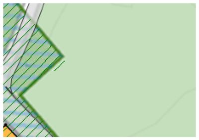 Dette er en detalj fra en situasjonsplan (tomteplan). Bildet viser et hjørne av eiendomsgrenser, der det grønne feltet representerer grøntområde eller tomt, og de skraverte områdene indikerer vannlegemer eller andre arealer med spesiell status. Det er også synlig en del av en bygning (hvit farge) i venstre hjørne.