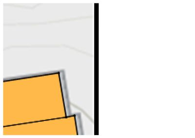 Et kartutsnitt som viser en del av en bygning (gult) og en svart linje som sannsynligvis representerer en vei eller grense.