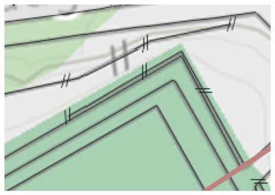 Dette er et utsnitt fra en situasjonsplan som viser en tomtegrense (grønn farge) med angitte avstander til nabogrenser (dobbeltstreker) og en vei (rød linje).