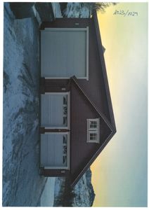 Fotografi av en bolig med garasje, sett fra siden, med snø på bakken.