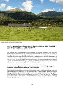 Fotografi av en gård med hus, hester og fjell i bakgrunnen.