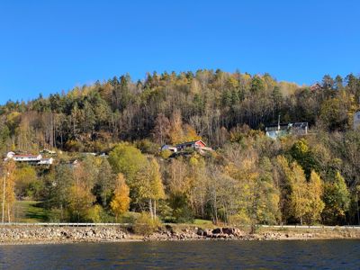 Fotografi av et boligområde på en skråning ved vannet.