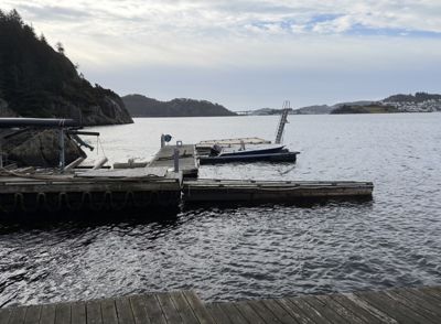 Fotografi av en kai med båt og utsikt over vannet.