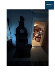 Fotografi av et interiør i en bygning, som viser en ovn, gulv og en døråpning.