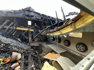 Fotografi av en bygning som har blitt hardt skadet av brann, med utslettet tak og innvendig skade.