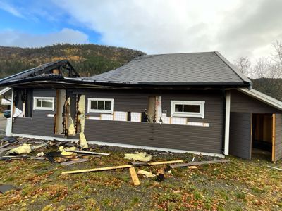 Fotografi av en bolig under ombygging eller renovering, med delvis fjernet fasade og tak.