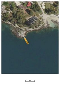 Satellittbilde (flyfoto) av et kystområde med en gule fargemerket struktur i vannet, sannsynligvis en brygge eller kai.