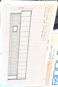 En håndtegnet fasadetekning som viser en vegg med vinduer og en dør.