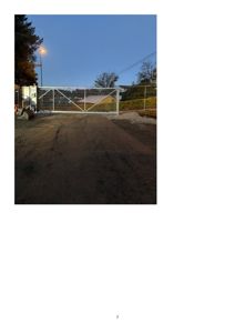 Fotografi av en gate med en hvit hekk og et gatehus.