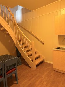 Fotografi av en innendørs trapp og kjøkkenområde med gulv og vegger.