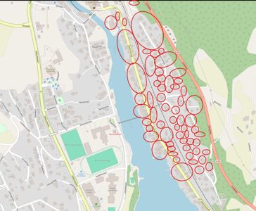 Kart over et område med bygningsplasseringer, veier og vannveier, med flere røde sirkler som markerer spesifikke eiendommer eller bygninger.