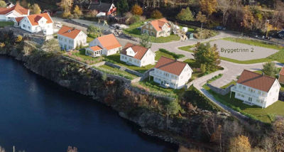 3D-visualisering av et boligfelt med flere hus langs en kystlinje, inkludert tekst 'Bygettrinn 2'.