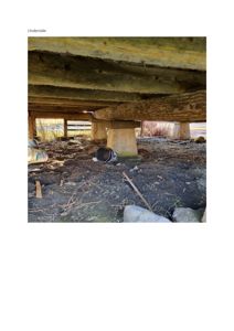 Fotografi av underside av en bygning, som viser konstruksjonen med bjelker og støtter.