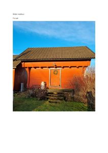 Fotografi av en rød stavby med en dør og et julekrans, sett fra sør.