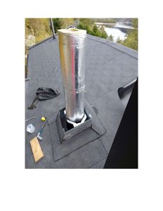 Fotografi av en nyinstallert, isolert røykledning på et tak under arbeid.