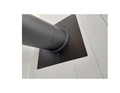 Fotografi av en metallrørledning (f.eks. ventilasjonsrør eller røykrør) som går gjennom et hvitt panelt tak.