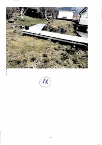 Fotografi av en utvendig del av en bygning, sannsynligvis en terrasse eller en del av en veranda, sett fra bakgården.