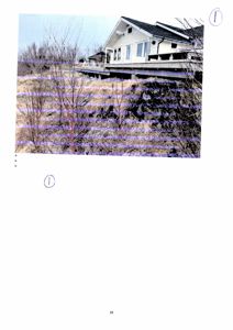 Fotografi av en hvit villa med etasjehus og terrasse, sett fra siden.