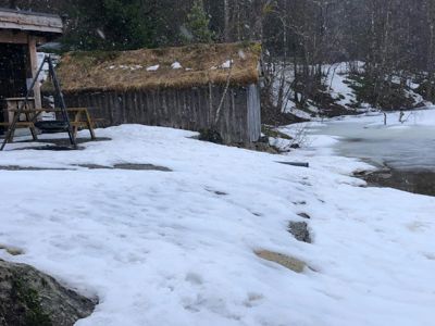 Fotografi av en bygning med grønt tak i snø, sett fra et lavt nivå.