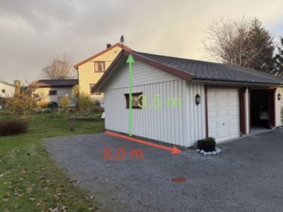 Fotografi av en hvit garasje med en gul bygning i bakgrunnen. Bildet har overlagte målinger (6,0 m og 3,5 m) som indikerer at det er brukt til å dokumentere dimensjoner.