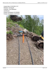 Fotografi av et utgravd område med spredegrøft, en orange markørstang og en grøftmaskin.