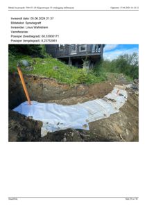 Fotografi av en utgravd grøft med en hvit spredegrøft (infiltrasjonssjikt) lagt i bunnen, med en bygning i bakgrunnen.