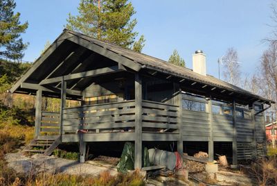 Fotografi av en ferdig eller nesten ferdig bygget hytte sett fra siden.