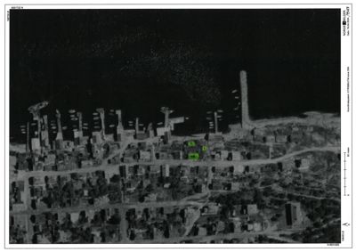 Luftfoto (flyfoto) av et nabolag med flere hus og en strandlinje i bakgrunnen. Bildet er presentert som en del av en byggesak med koordinater og skala.