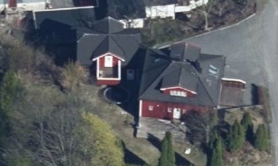 Luftfoto av en rød bygning med svart tak sett fra oven.