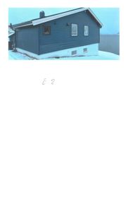 Fotografi av en blå hytte sett fra siden, med snø på bakken.