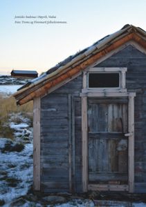 Fotografi av en gammel, trebygget badstue (Jomisko-badstua) i Høyvik, Vadsø, med snø i bakgrunnen.
