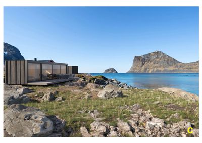 Fotografi av en moderne, langhusformet bygning plassert på en kyststrøk med fjell i bakgrunnen.