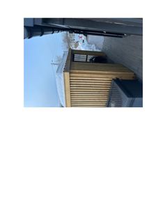 Fotografi av en ferdig eller under oppføring bygning med trepanelvegg og tak, sett fra utsiden i snø.