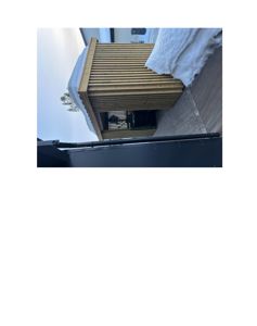 Fotografi av en ferdig bygning eller utvidelse med trepanelvegg og snø på taket og i bakgrunnen.