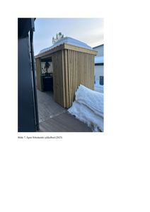 Fotografi av en frittstående sykkelpåbyggning (sykkelbod) med snø på taket og gulv.