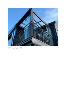 Fotografi av en innvendig glassfasade (åpen) på en bygning, med blå himmel i bakgrunnen.