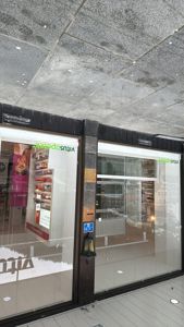 Fotografi av fasaden på en Vitusapotek-butikk, inkludert vinduer, inngang og golv.