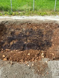 Fotografi av en utgravd grøft eller grunnarbeid på en byggeplass.