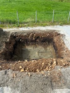 Fotografi av en utgravd grøft eller grunnarbeid på en byggeplass.