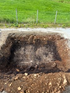 Fotografi av en utgravd grøft eller fundamenteringsgrøft på en byggeplass.
