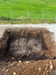 Fotografi av en utgravd grøft eller fundamenteringsgrøft på en byggeplass.