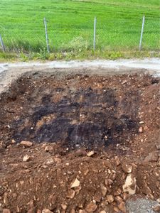 Fotografi av en utgravd grøft eller fundamenteringsgrøft på en byggeplass.
