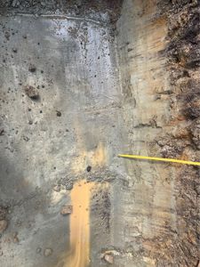 Fotografi av en graving eller utgravning i jorda, sannsynligvis en del av en byggeplass eller grunnarbeider.