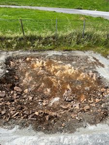 Fotografi av en utgravd grunnflate med stein og jord, sannsynligvis på en byggeplass.